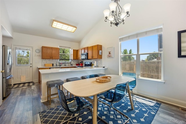 1884 Asoka St, Strasburg, CO 80136 - dining space with a chandelier, dark wood-style floors, and lofted ceiling