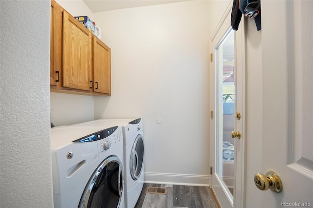 1884 Asoka St, Strasburg, CO 80136 - washroom with washer and dryer, dark wood-type flooring, and cabinet space