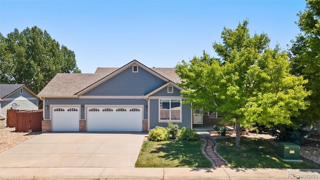 1884 Asoka St, Strasburg, CO 80136 - view of front facade with an attached garage, driveway, brick siding, and roof with shingles