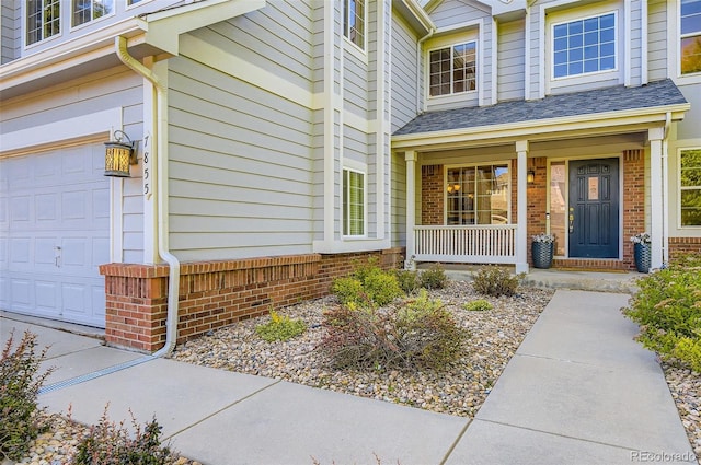 7855 Arundel Ln, Lone Tree, CO 80124 - property entrance featuring covered porch, a garage, and brick siding