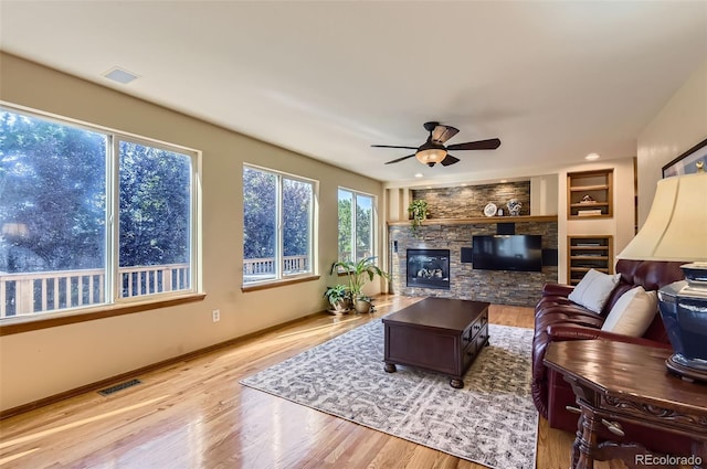 7855 Arundel Ln, Lone Tree, CO 80124 - living area featuring wood finished floors, ceiling fan, and a stone fireplace