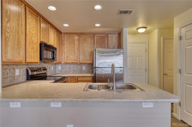 kitchen featuring backsplash, sink, hardwood / wood-style flooring, appliances with stainless steel finishes, and kitchen peninsula