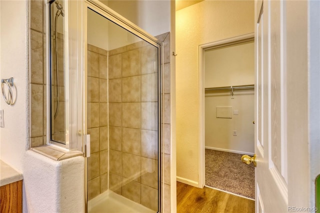 bathroom with hardwood / wood-style flooring and walk in shower