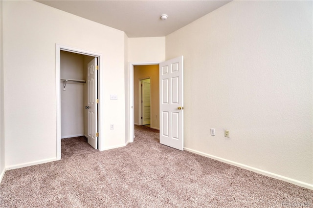 unfurnished bedroom featuring light carpet and a closet