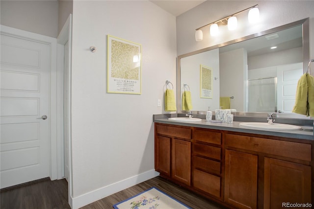 bathroom featuring hardwood / wood-style floors, vanity, and a shower with shower door