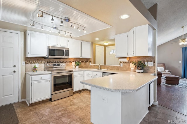 7598 Jared Way, Littleton, CO 80125 - kitchen with stainless steel appliances, white cabinets, a peninsula, ceiling fan, and recessed lighting
