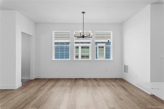 213 Washington St, Erie, CO 80516 - unfurnished dining area with a chandelier, wood finished floors, and baseboards