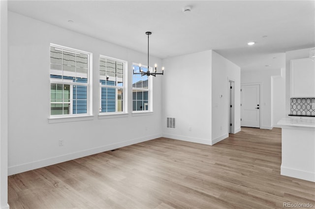 213 Washington St, Erie, CO 80516 - unfurnished dining area featuring a chandelier, plenty of natural light, light wood finished floors, baseboards, and recessed lighting