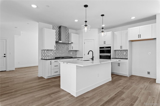 213 Washington St, Erie, CO 80516 - kitchen with wall chimney range hood, stovetop, recessed lighting, decorative backsplash, and white cabinetry