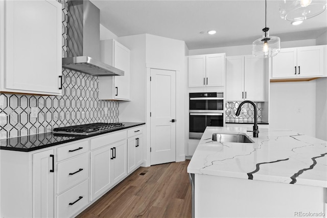 213 Washington St, Erie, CO 80516 - kitchen featuring wall chimney exhaust hood, a sink, wood finished floors, appliances with stainless steel finishes, and white cabinetry