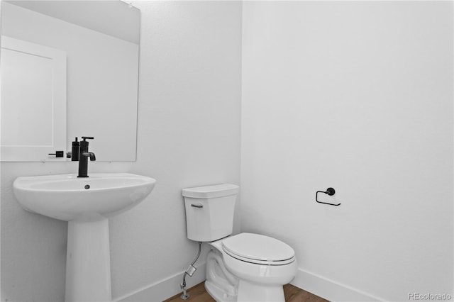 213 Washington St, Erie, CO 80516 - half bath featuring toilet, baseboards, wood finished floors, and a sink
