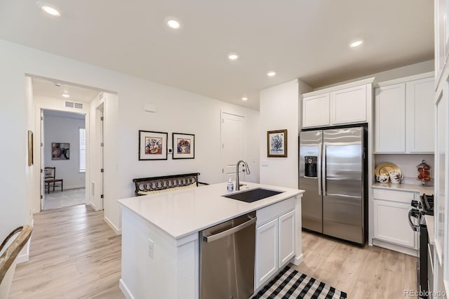 15919 Xanthia Way, Thornton, CO 80602 - kitchen featuring appliances with stainless steel finishes, a sink, light wood finished floors, white cabinets, and recessed lighting