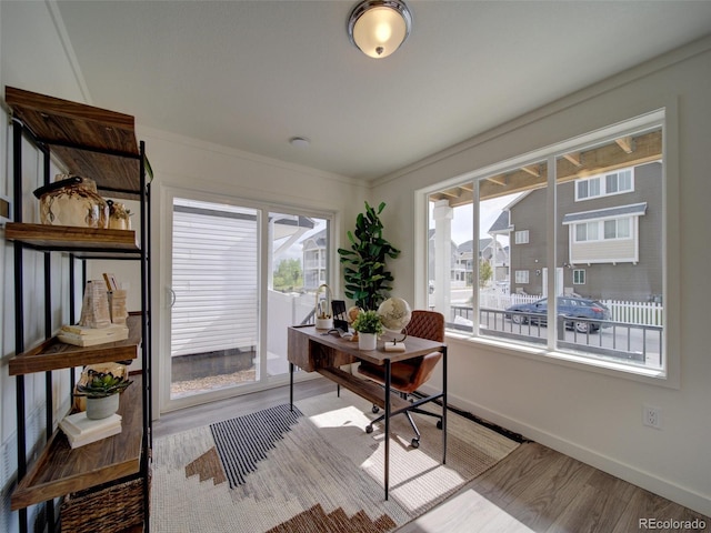 office with a healthy amount of sunlight, light wood-type flooring, and ornamental molding