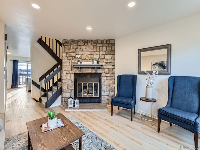 living room with recessed lighting, a fireplace, wood finished floors, baseboards, and stairway