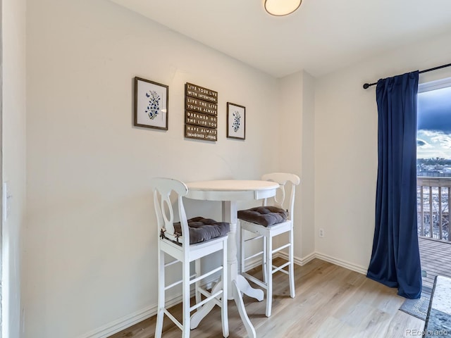 dining area with light wood-type flooring and baseboards