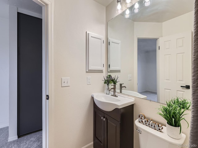 bathroom featuring baseboards, vanity, and toilet