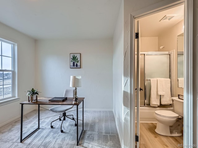 office with baseboards, visible vents, and wood finished floors