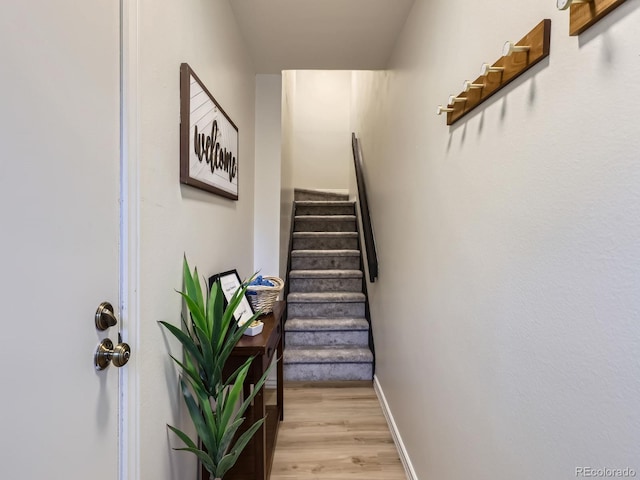 stairway with baseboards and wood finished floors