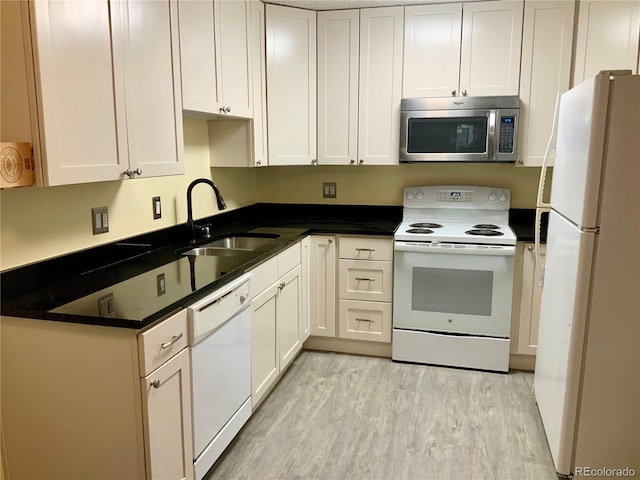 kitchen featuring white cabinetry, sink, white appliances, and light hardwood / wood-style floors