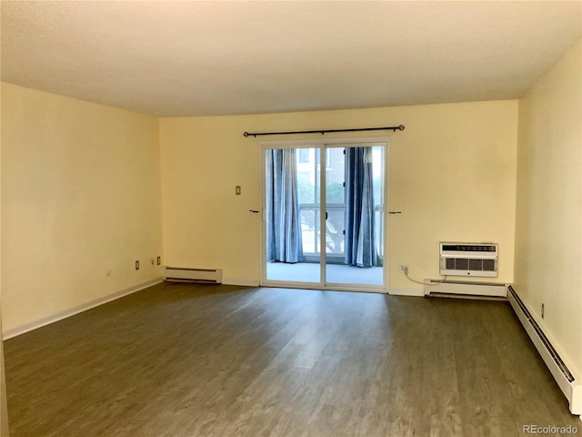 spare room with a baseboard heating unit, a wall unit AC, and dark hardwood / wood-style floors