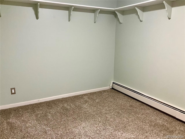 walk in closet with a baseboard heating unit and carpet flooring