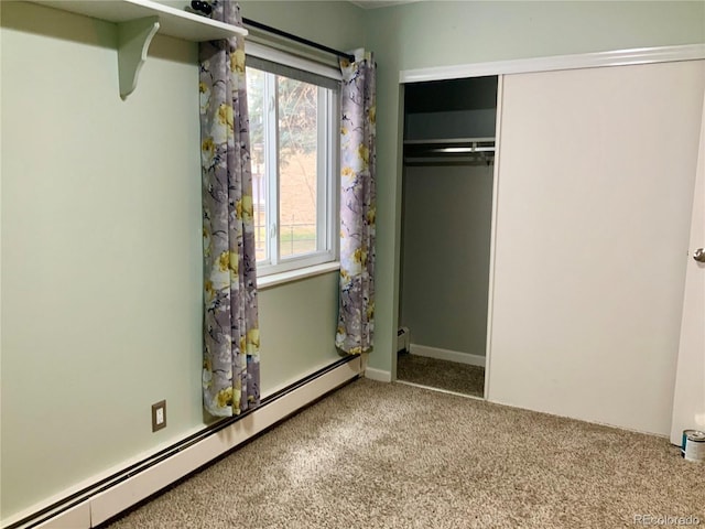 unfurnished bedroom featuring a baseboard radiator, carpet floors, and a closet