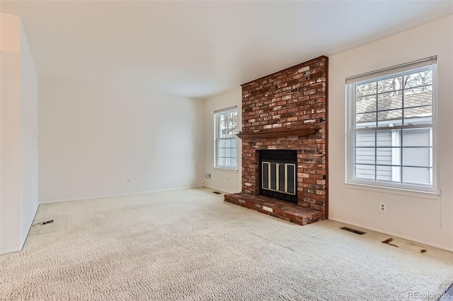 unfurnished living room with light colored carpet and a fireplace