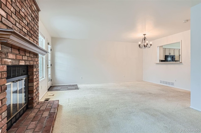 unfurnished living room with a brick fireplace, dark carpet, and a chandelier