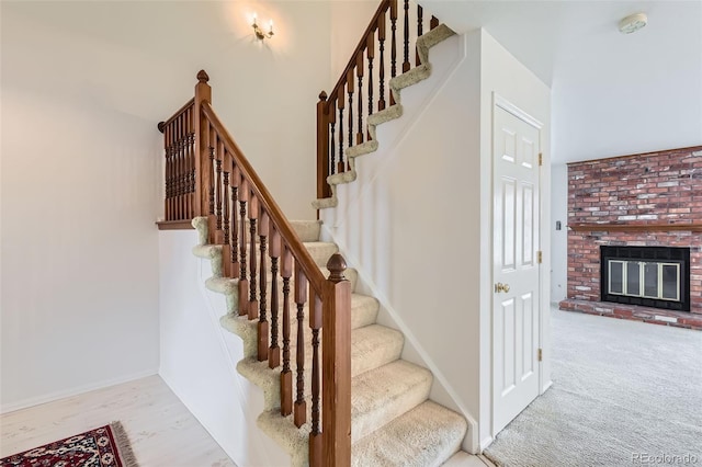 stairway featuring carpet flooring and a fireplace