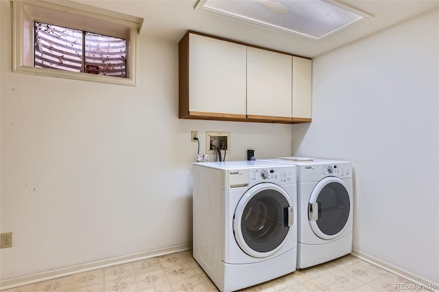 clothes washing area with cabinets and separate washer and dryer