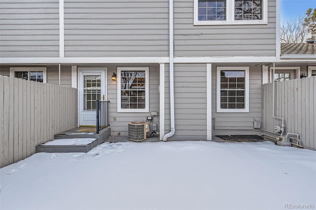 snow covered property entrance featuring central air condition unit