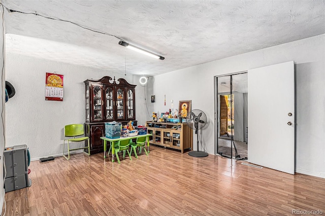 miscellaneous room featuring hardwood / wood-style floors and a textured ceiling