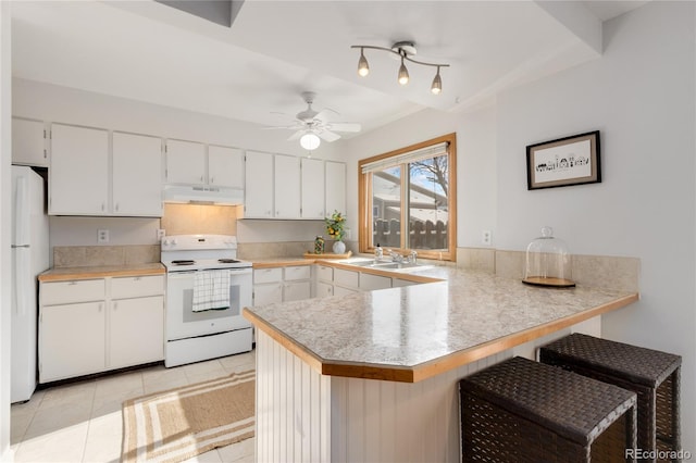 kitchen with white appliances, kitchen peninsula, and white cabinets