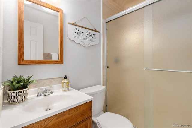 bathroom with walk in shower, vanity, and toilet