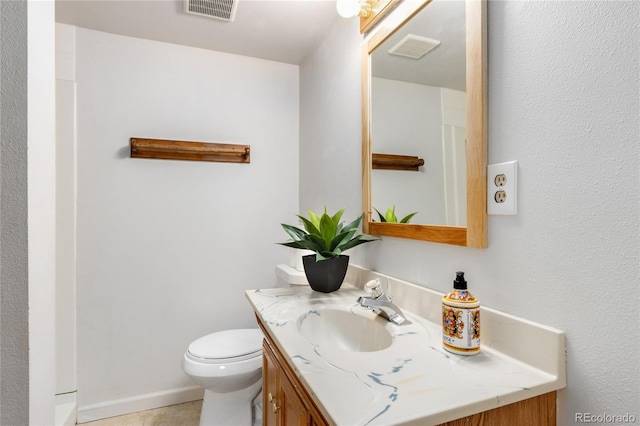 bathroom with tile patterned flooring, vanity, and toilet