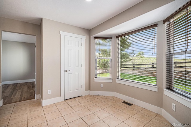 unfurnished bedroom featuring baseboards and light tile patterned flooring