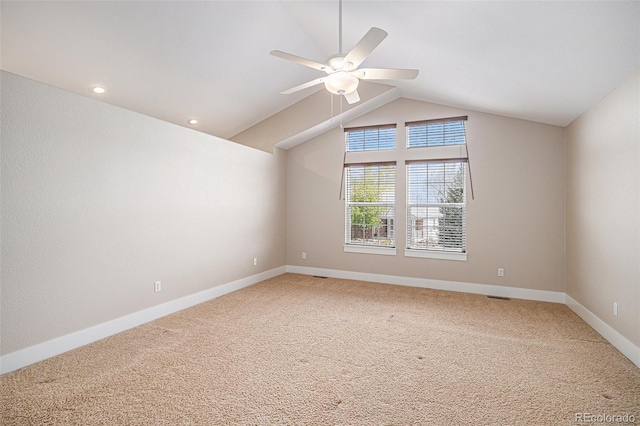 empty room with a ceiling fan, lofted ceiling, light carpet, and baseboards
