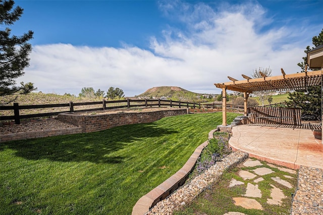 view of yard featuring a pergola, a patio, and a mountain view