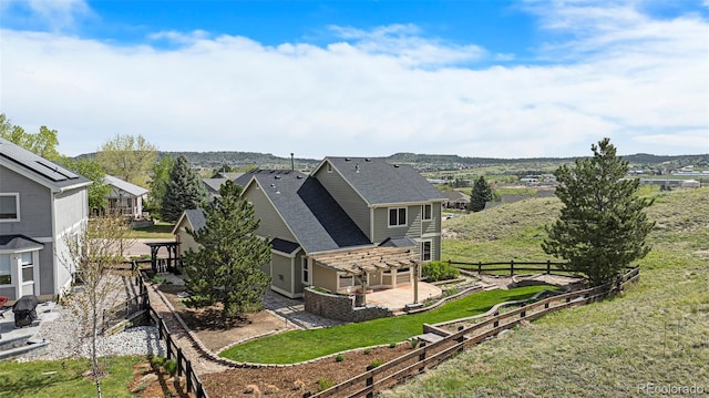 back of house featuring a fenced backyard, a residential view, and a patio