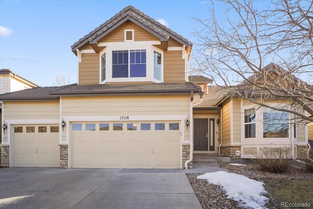 view of front facade featuring stone siding, driveway, a tiled roof, and an attached garage