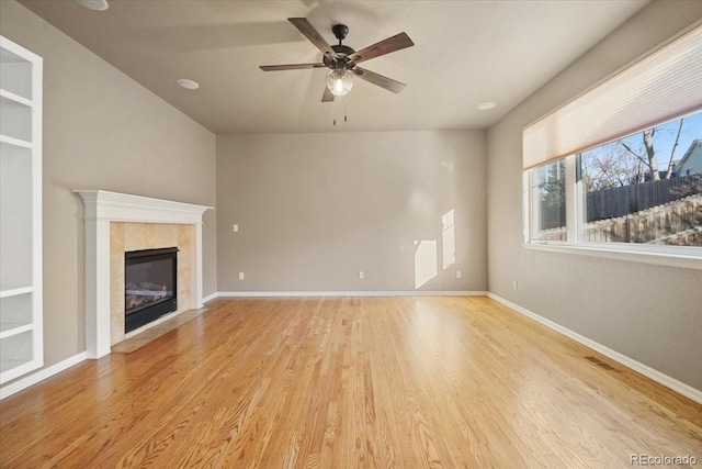 unfurnished living room featuring visible vents, a fireplace, baseboards, and wood finished floors