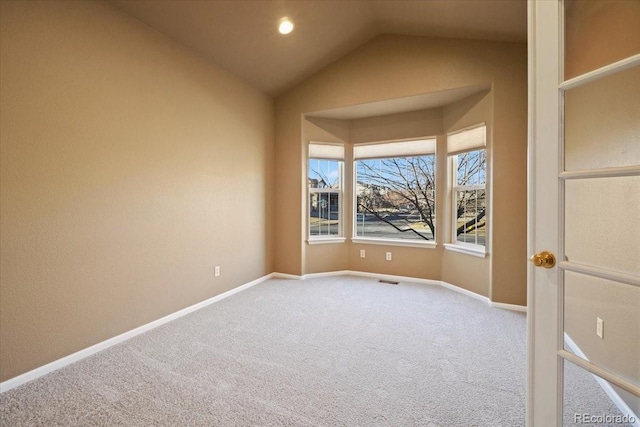 carpeted spare room with recessed lighting, vaulted ceiling, and baseboards