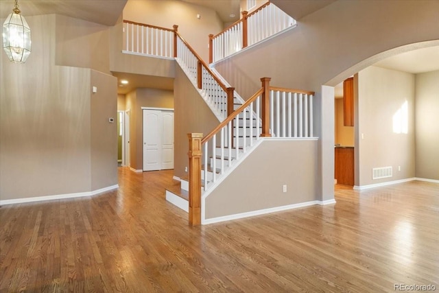 interior space featuring arched walkways, wood finished floors, visible vents, and baseboards