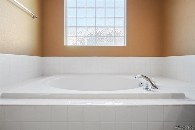 bathroom featuring a wealth of natural light and a garden tub