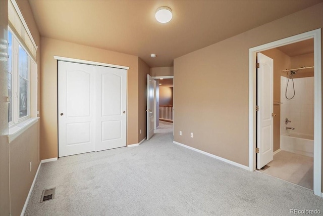 unfurnished bedroom with carpet floors, a closet, visible vents, and baseboards