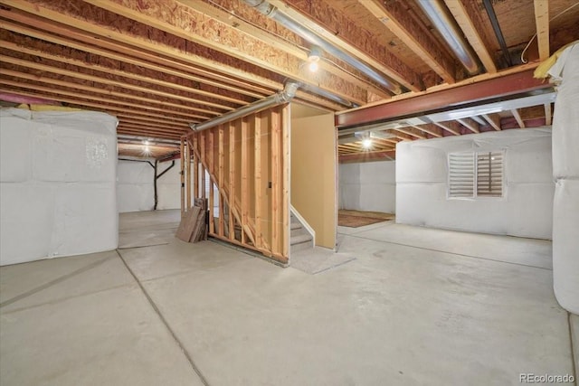 unfinished basement featuring stairs