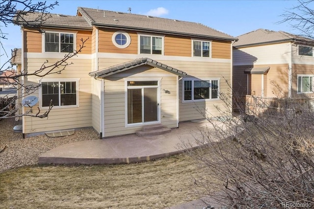 rear view of property featuring a patio area and a tile roof