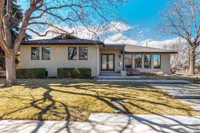 view of front of home featuring french doors, a front yard, and stucco siding