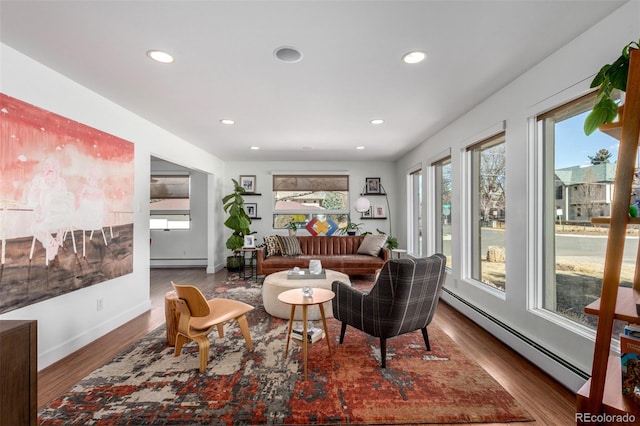 living room with a baseboard heating unit, recessed lighting, baseboard heating, and wood finished floors