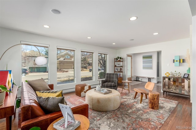 living room featuring a baseboard heating unit, wood finished floors, and recessed lighting